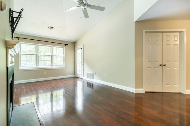 unfurnished living room with lofted ceiling, wood finished floors, baseboards, and a ceiling fan