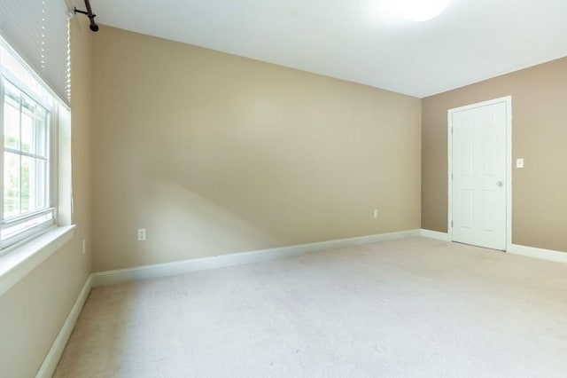 empty room with light carpet and baseboards