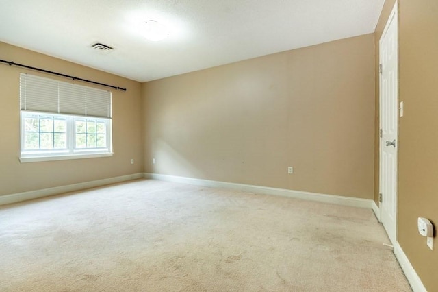 spare room with light colored carpet and baseboards