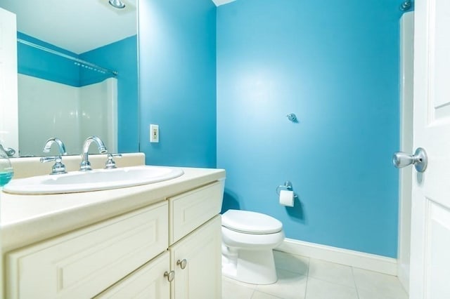 full bath with tile patterned flooring, vanity, toilet, and baseboards