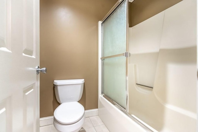 bathroom with tile patterned flooring, baseboards, toilet, and shower / bath combination with glass door