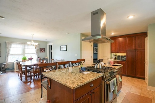 1013 Pleasant St, Worcester, MA 01602 - kitchen with stainless steel range with gas cooktop, island range hood, a kitchen breakfast bar, a center island, and a chandelier