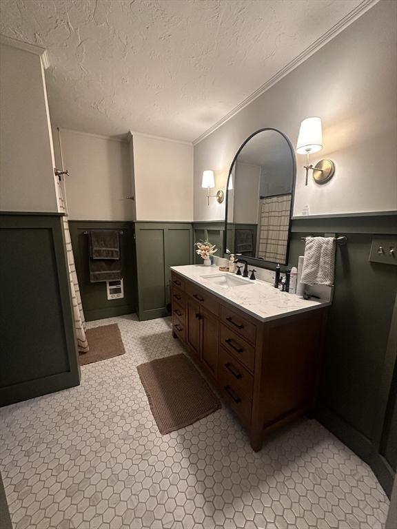 1013 Pleasant St, Worcester, MA 01602 - bathroom with ornamental molding, vanity, wainscoting, and a textured ceiling