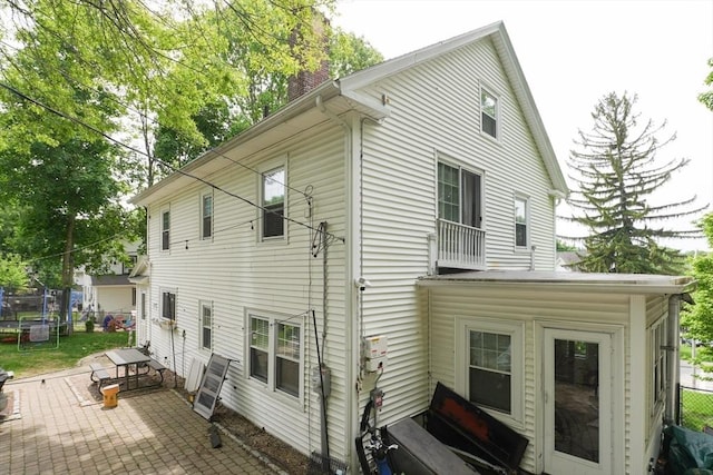 1013 Pleasant St, Worcester, MA 01602 - back of house featuring a trampoline, a patio, and a chimney