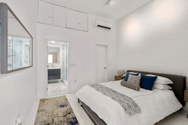 bedroom featuring a wall unit AC and connected bathroom