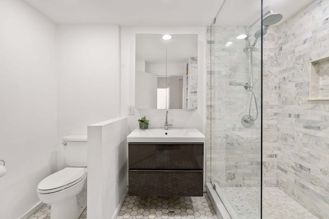 bathroom with tile patterned flooring, toilet, a tile shower, and vanity