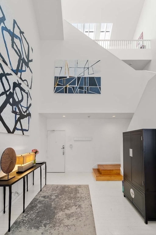 entryway featuring high vaulted ceiling and a skylight