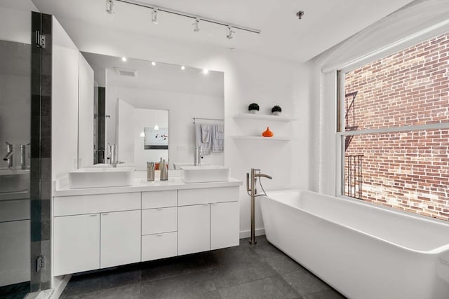 bathroom with plenty of natural light, separate shower and tub, vanity, and tile patterned floors