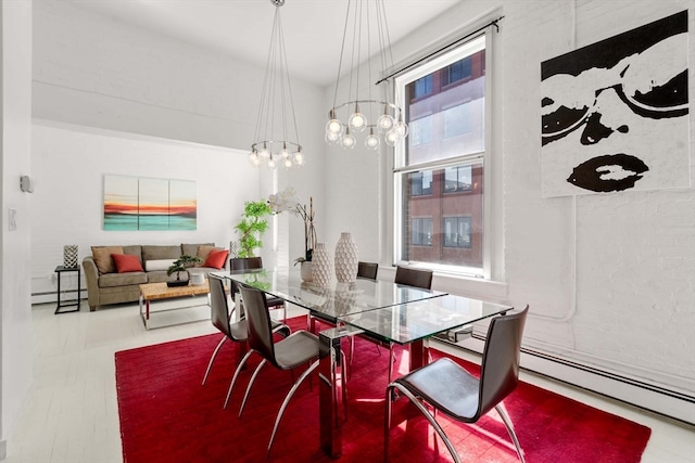 dining space featuring a baseboard heating unit and an inviting chandelier