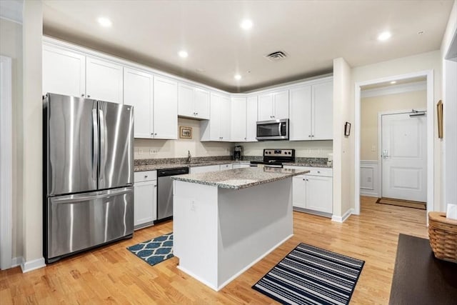 90 Trotter Rd Unit 309, Weymouth, MA 02190 - kitchen with stainless steel appliances, light wood finished floors, light stone countertops, a kitchen island, and recessed lighting