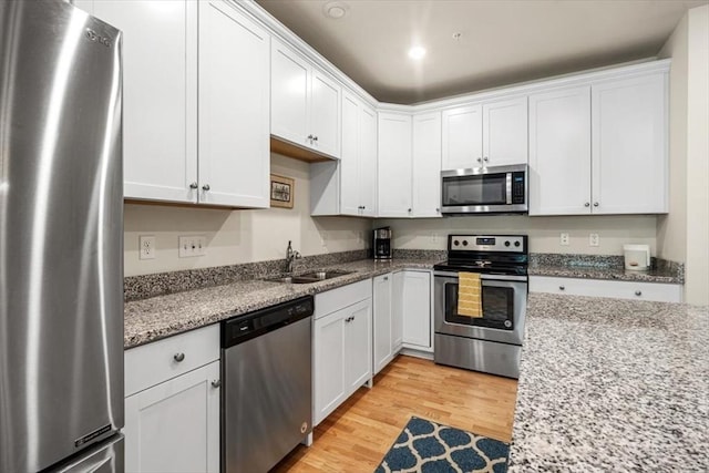 90 Trotter Rd Unit 309, Weymouth, MA 02190 - kitchen with appliances with stainless steel finishes, light wood-type flooring, and white cabinetry