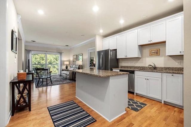 90 Trotter Rd Unit 309, Weymouth, MA 02190 - kitchen featuring appliances with stainless steel finishes, open floor plan, crown molding, stone countertops, and a center island