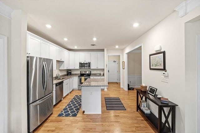 90 Trotter Rd Unit 309, Weymouth, MA 02190 - kitchen featuring stainless steel appliances, white cabinets, light wood-style flooring, recessed lighting, and a center island