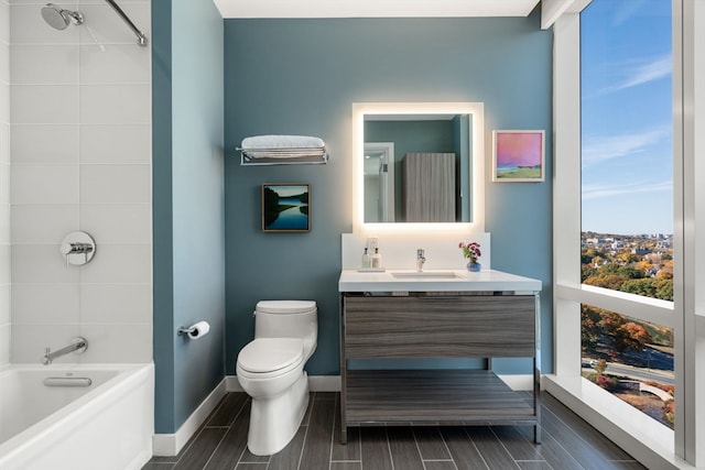 full bathroom featuring vanity, toilet, hardwood / wood-style flooring, and tiled shower / bath