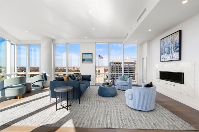 living room featuring a premium fireplace, hardwood / wood-style flooring, and floor to ceiling windows