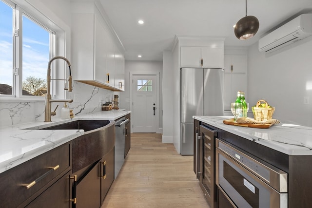 kitchen with plenty of natural light, white cabinetry, and appliances with stainless steel finishes