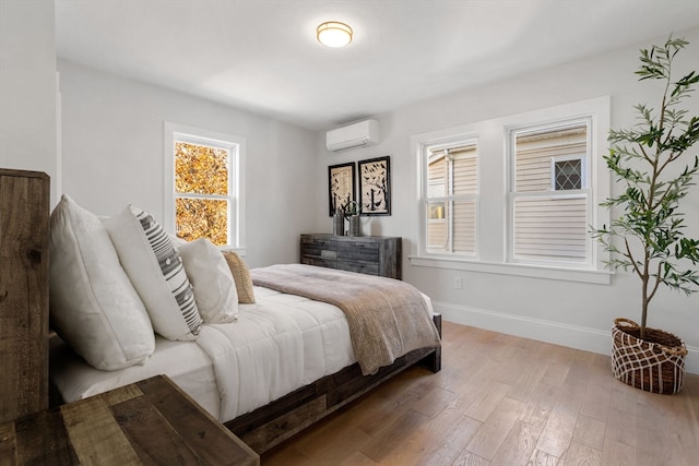 bedroom with hardwood / wood-style floors and a wall mounted AC