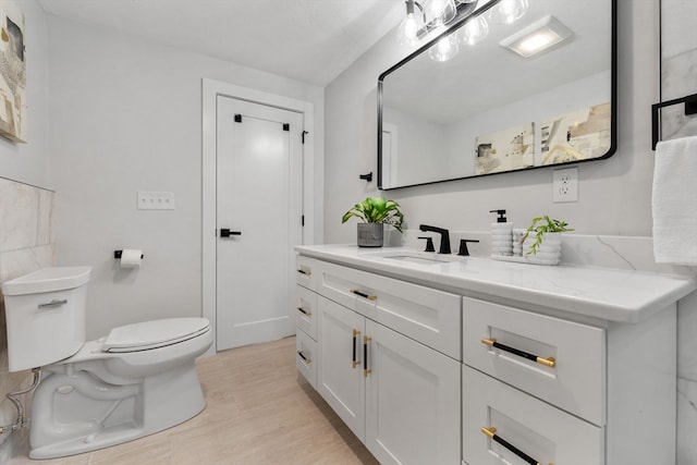 bathroom with hardwood / wood-style floors, vanity, and toilet