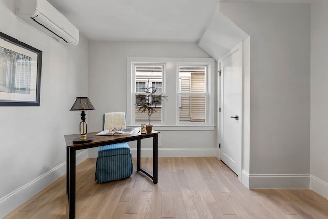 office area with light hardwood / wood-style floors and an AC wall unit