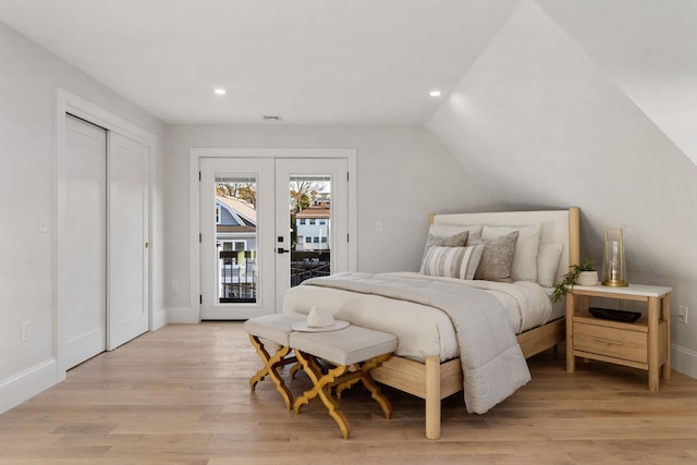 bedroom featuring lofted ceiling, access to outside, french doors, light hardwood / wood-style floors, and a closet