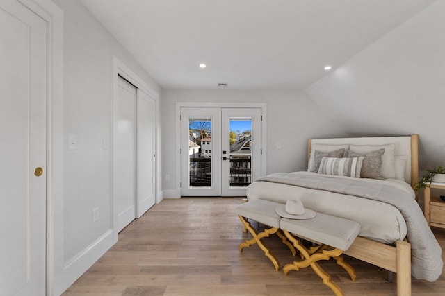 bedroom with vaulted ceiling, light hardwood / wood-style flooring, access to outside, and french doors