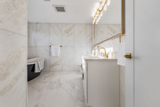 bathroom with vanity, a tub to relax in, toilet, and tile walls