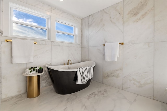 bathroom with a bathtub and tile walls