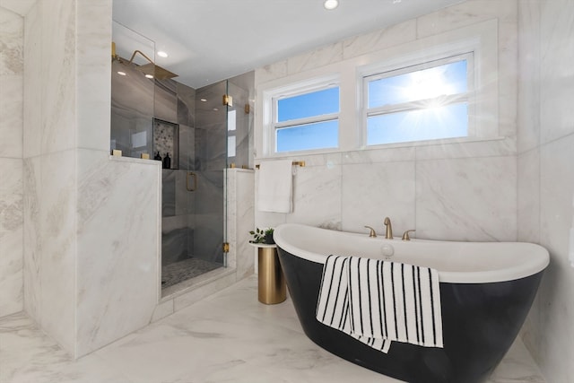 bathroom featuring tile walls and independent shower and bath