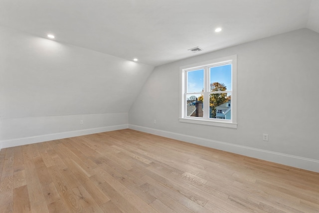 empty room featuring light hardwood / wood-style floors and vaulted ceiling