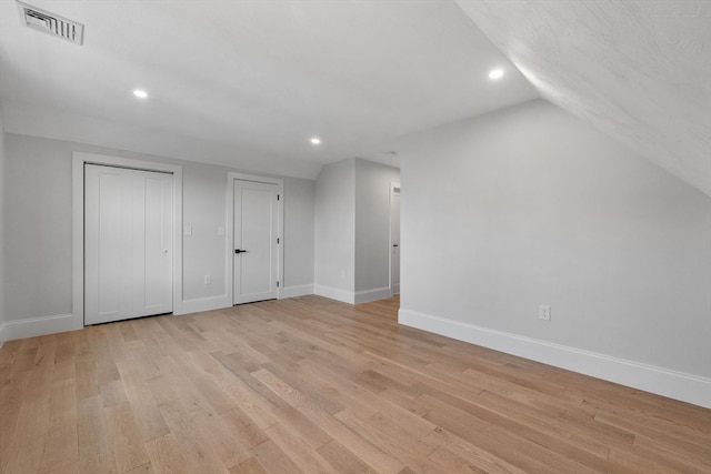 additional living space with light wood-type flooring and vaulted ceiling