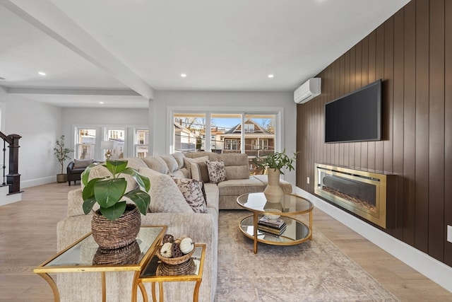 living room featuring beam ceiling, light hardwood / wood-style flooring, a wall mounted AC, and wooden walls