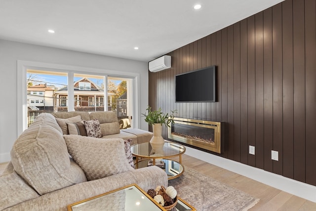 living room featuring an AC wall unit, wooden walls, and wood-type flooring