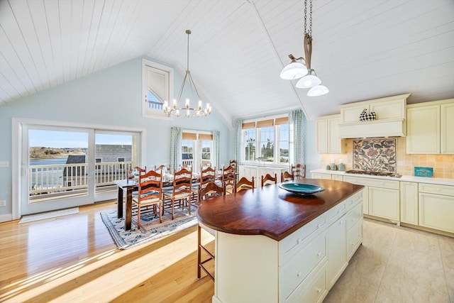 kitchen featuring pendant lighting, plenty of natural light, stainless steel gas cooktop, and tasteful backsplash