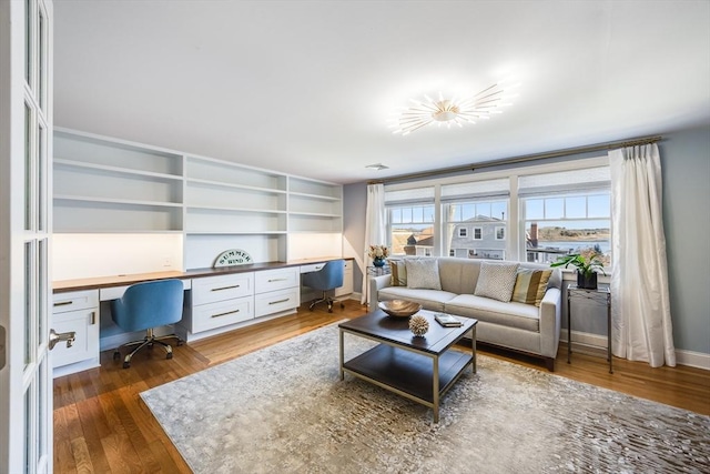 living room with built in desk and dark wood-type flooring