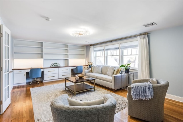 living room featuring built in desk and hardwood / wood-style floors