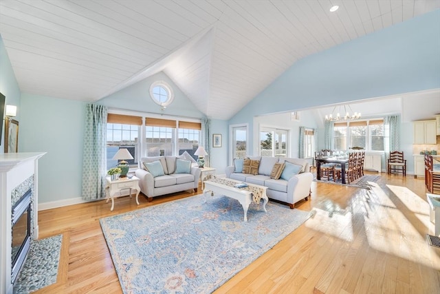 living room with light hardwood / wood-style floors, wooden ceiling, and plenty of natural light