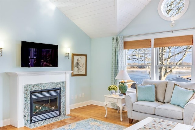 living room with hardwood / wood-style floors, lofted ceiling, and a fireplace