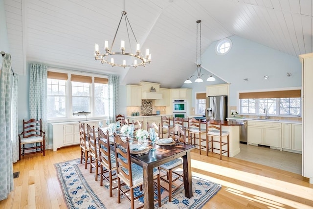 dining room with wood ceiling, high vaulted ceiling, sink, light hardwood / wood-style flooring, and an inviting chandelier