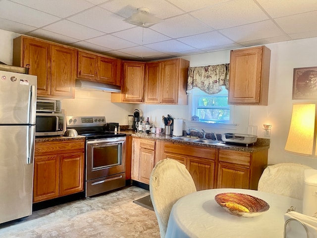 kitchen featuring appliances with stainless steel finishes, a drop ceiling, and sink