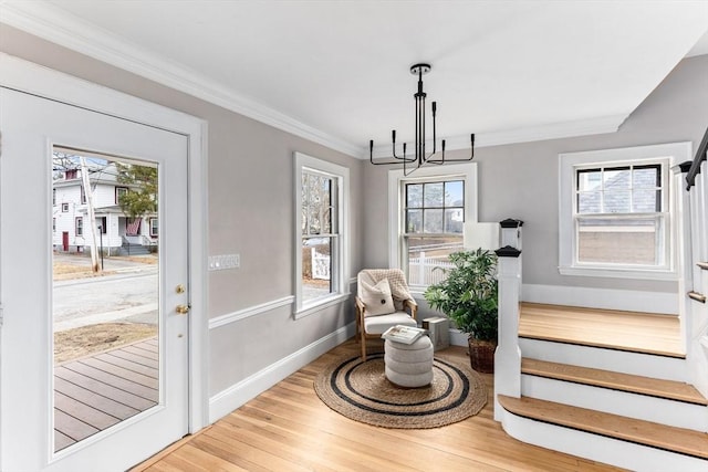 sitting room with plenty of natural light, crown molding, baseboards, and wood finished floors