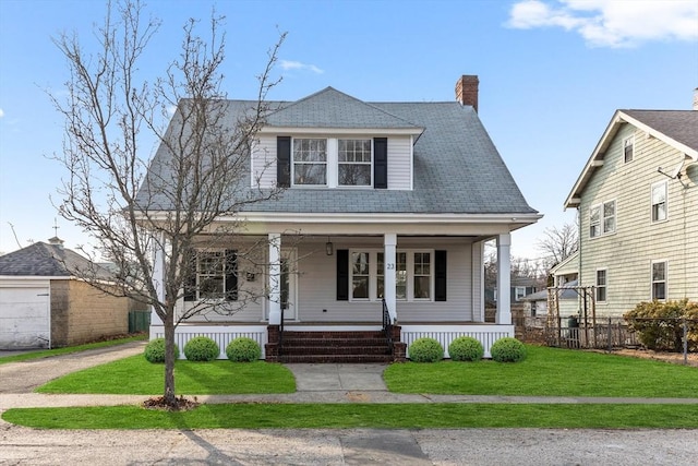 view of front of house with a front yard, covered porch, and a chimney