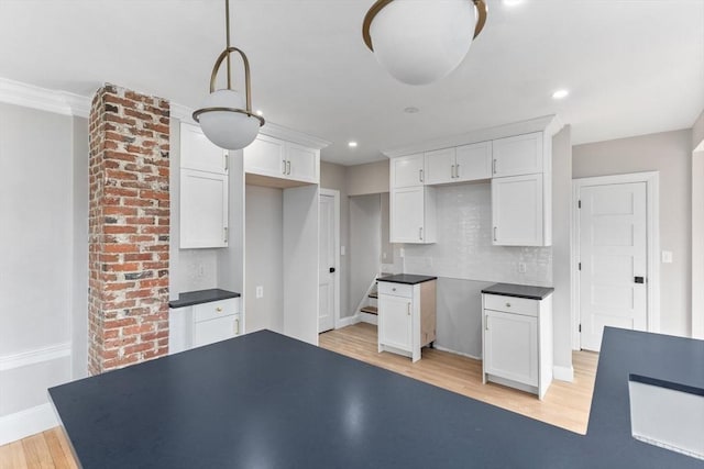 kitchen with recessed lighting, white cabinets, light wood finished floors, tasteful backsplash, and dark countertops