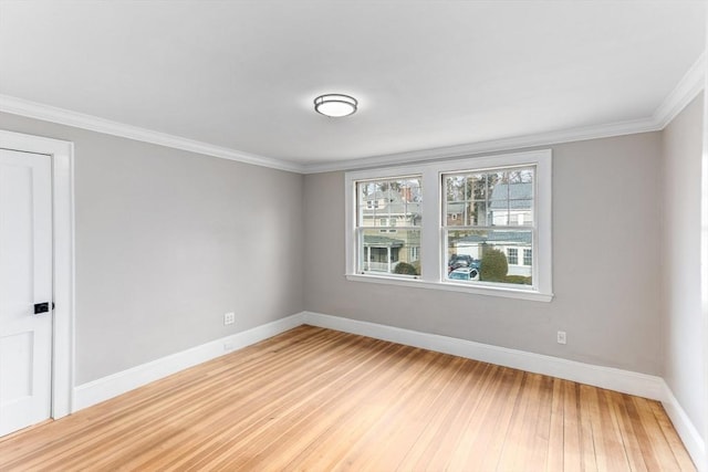 unfurnished room with crown molding, light wood-style flooring, and baseboards