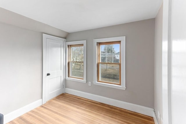 spare room with light wood-style floors and baseboards