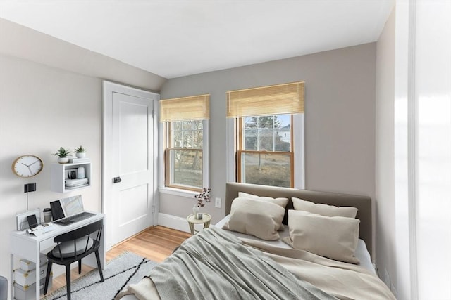 bedroom with light wood-style flooring and baseboards