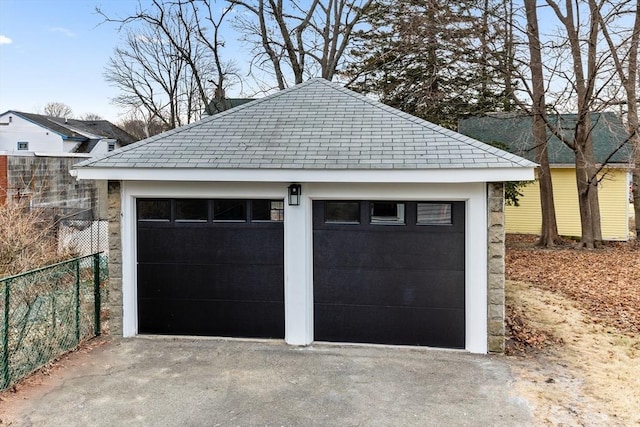 detached garage featuring fence