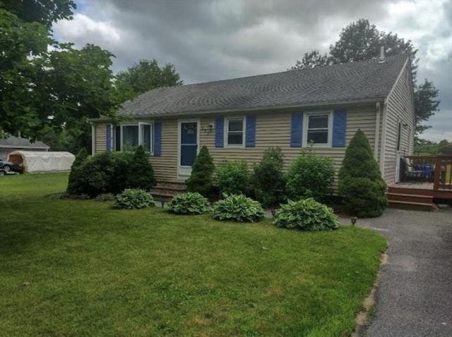 view of front of house with a front yard and a wooden deck