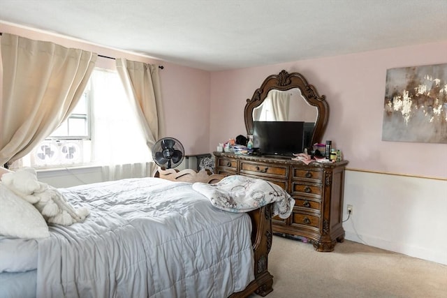 bedroom with cooling unit and light colored carpet