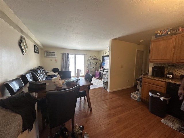 dining room with an AC wall unit, dark wood finished floors, and baseboards