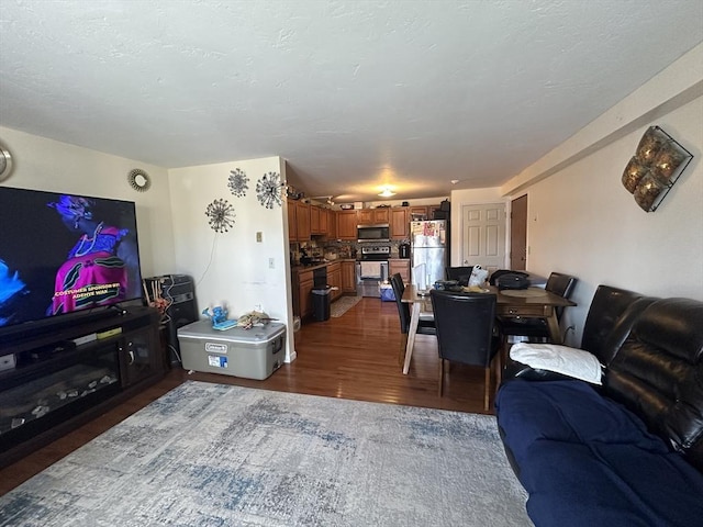 living area with a textured ceiling and dark wood-style flooring